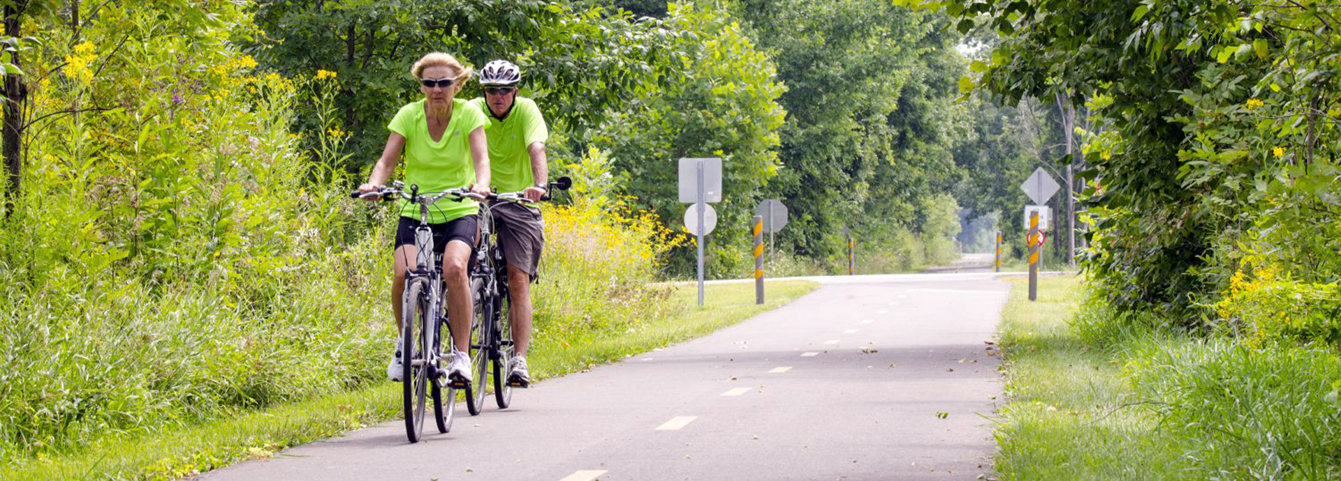 Slideshow Image - An elderly couple biking on the B&O trail