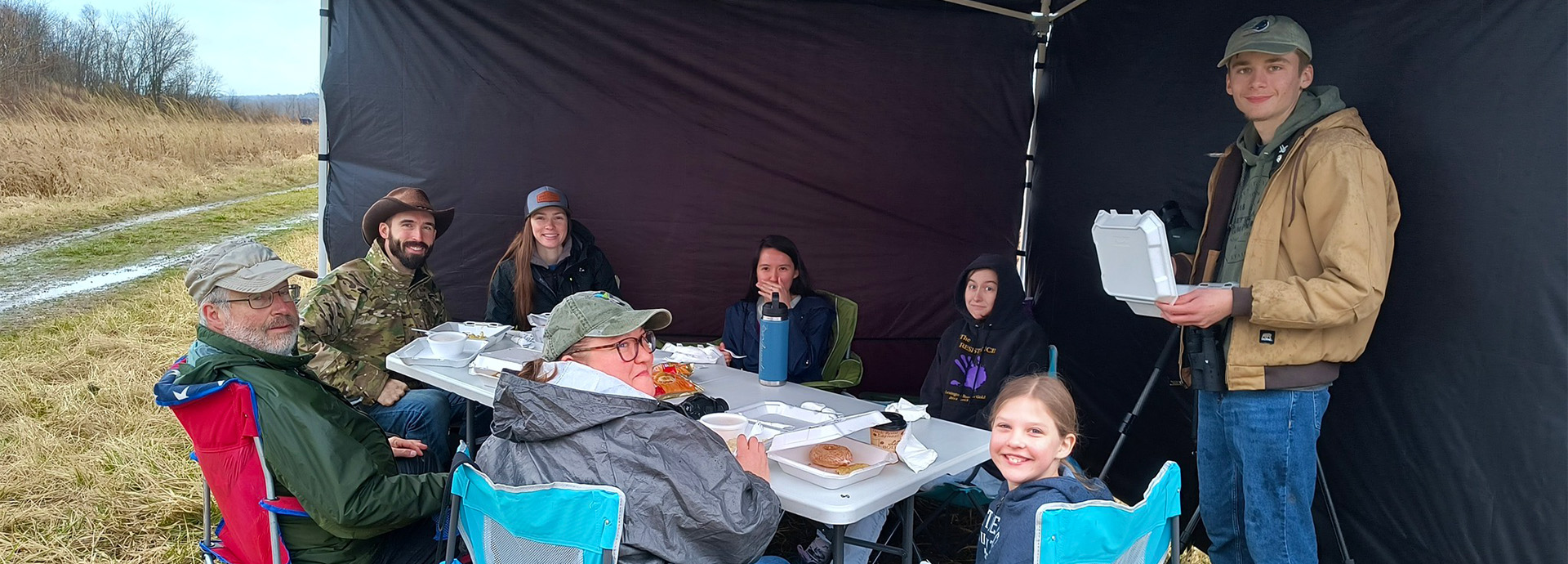 Slideshow Image - Several employees eating lunch in an outdoor tent