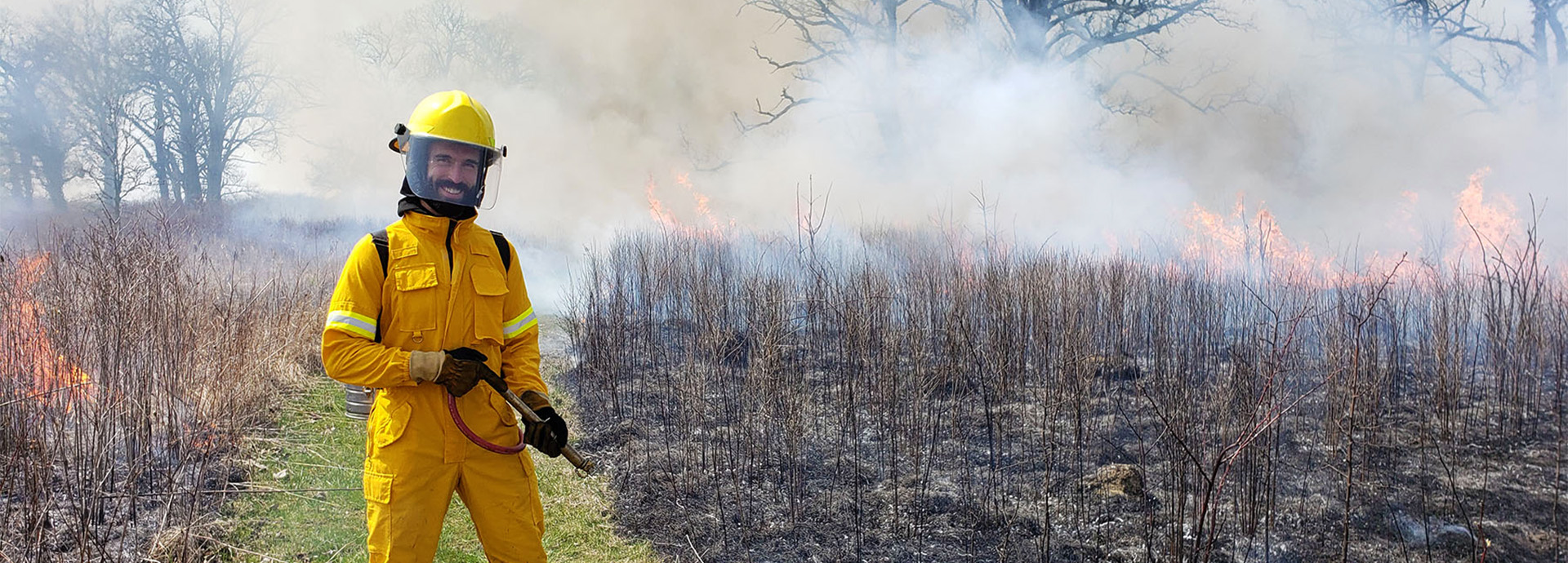 Slideshow Image - An employee performing a controlled prairie burn